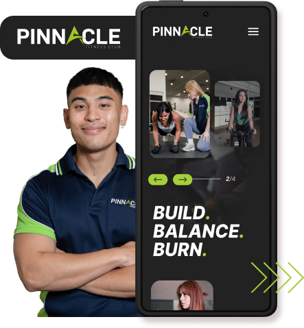 A person in a 'Pinnacle Fitness Club' polo stands next to a phone displaying the club's app interface, which shows images of people working out and the phrases "Build. Balance. Burn." It's the perfect time to revamp your website with our dynamic fitness content to attract new clients.