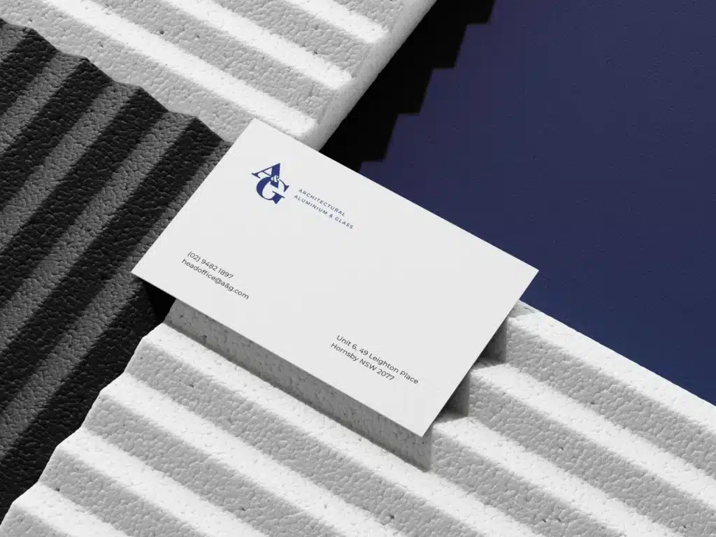 A sleek business card for Architectural Glazing & Cladding, showcasing contact details and a vibrant blue logo. Perfect for textured surfaces, it integrates creativity with precision. If you're looking for modern design solutions, this is your go-to source.