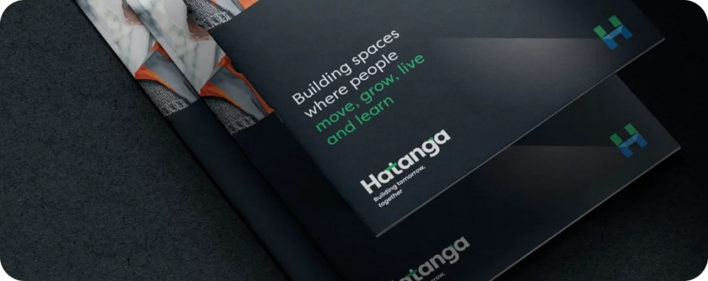 Stacked dark brochures with "Building spaces where people move, grow, live and learn" in white and green text, showcasing Hatanga's expertise. The branding highlights their strength as an agency at the forefront of innovative construction.