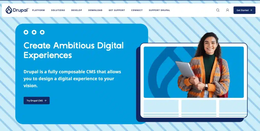 An individual with a laptop stands beside a screen showcasing "Create Ambitious Digital Experiences" with Drupal branding, a perfect pick for eCommerce CMS needs, especially tailored for Australian businesses.