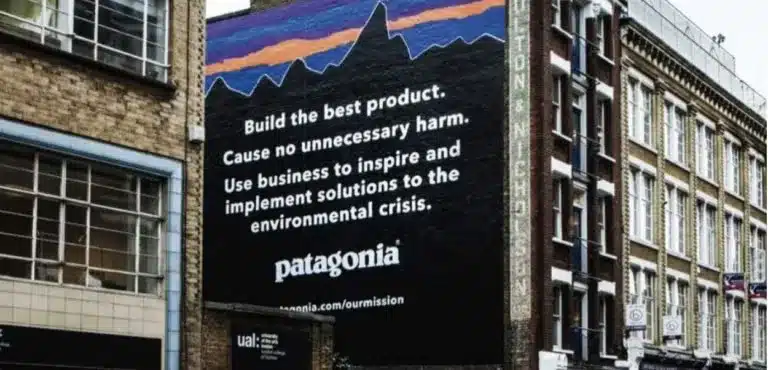 A mural on a building showcases Patagonia's brand identity, featuring their mission statement advocating for quality products and environmental responsibility, with a link for more information.