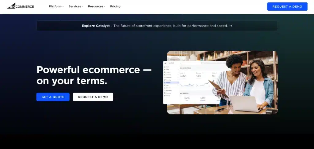 Website homepage featuring a promotional banner for an eCommerce CMS platform. Two people look at a laptop displaying analytics, ideal for Australian businesses. Buttons read "Get a Quote" and "Request a Demo.