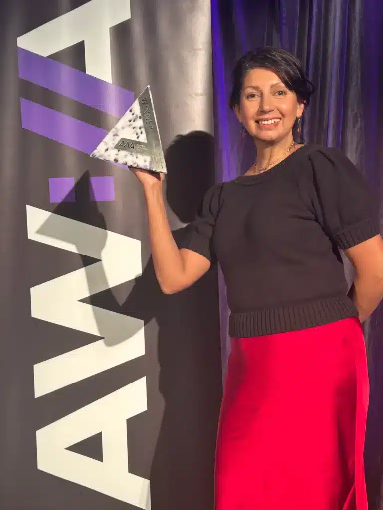 Carol Lobo, Founder at Spark Interact holds up the Australian Web Awards trophy won at 2025 Awards Night.