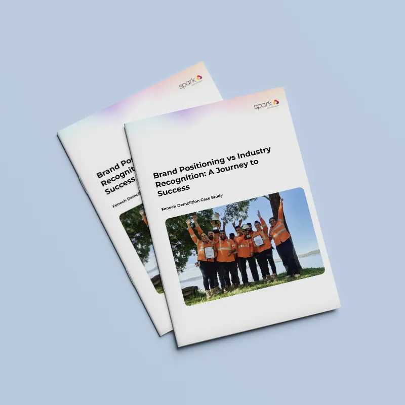 Two booklets titled "Brand Positioning vs Industry Recognition: A Journey to Success," featuring a group photo of people in orange vests, are displayed on a light blue background—perfect for those looking to reposition your business or explore rebranding.