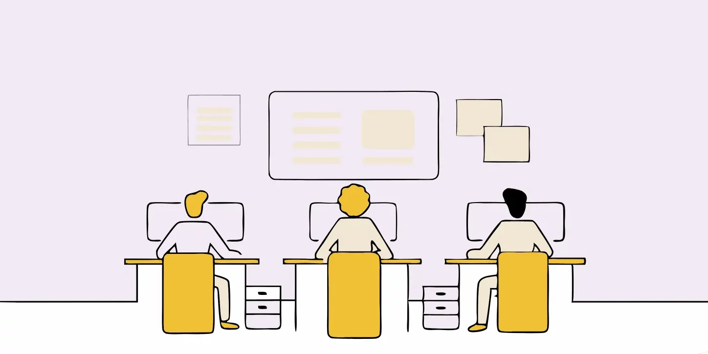 Three people are sitting at desks with computers in an office environment, collaborating on SEO Content Strategy as they face a wall with papers and a large screen or board.