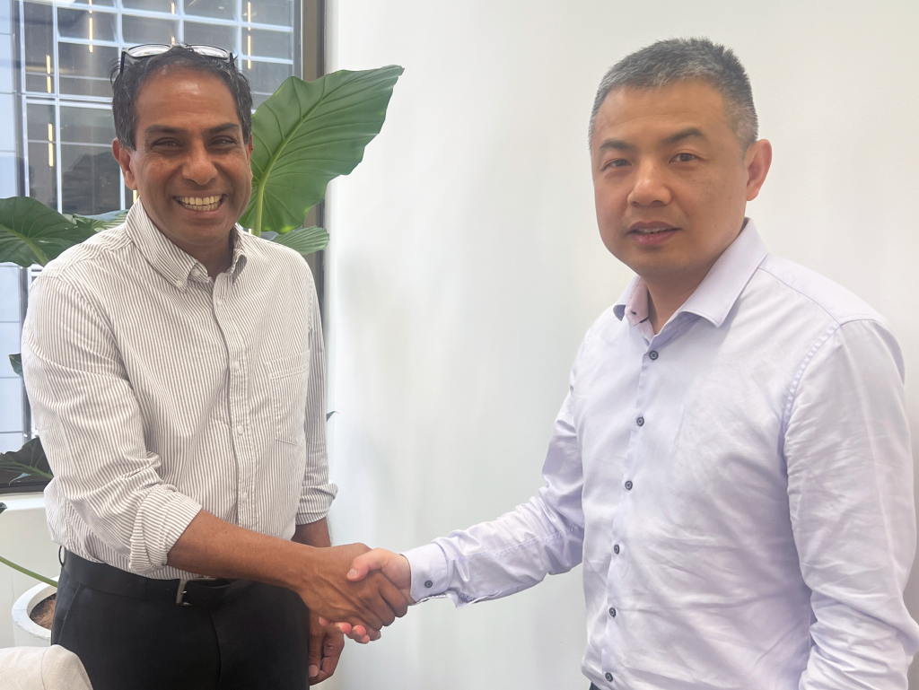 Mackey Kandarajah and Dr Qi Zhang shake hands reflecting a successful IP partnership and commitment to brand protection.