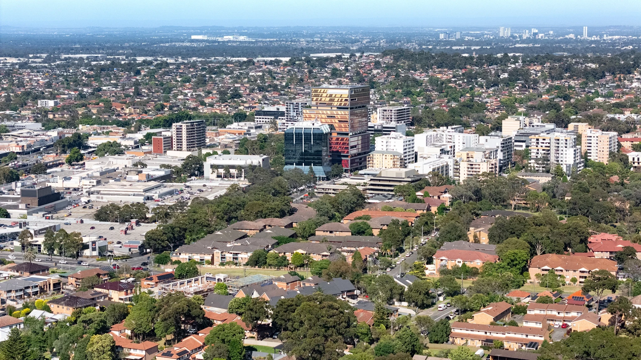Aerial view of Parramatta with residential houses in the foreground and mid-rise commercial and apartment buildings in the background under a clear sky—ideal for showcasing web design developments in urban settings.